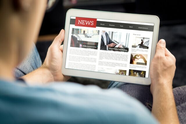 Person reads news on a tablet, focussing on different topics.