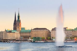 Hotel Atlantic Hamburger Rathaus und Binnenalsterbrunnen bei Sonnenuntergang, Hamburg, Deutschland.