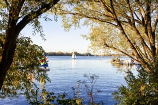 Hotel Atlantic Sailing boat on calm water, surrounded by trees and autumn landscape.