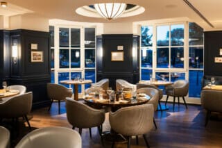 Elegant restaurant interior with stylish tables and cosy chairs at dusk.