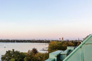 View of the lake with trees and city view in the background at sunset.